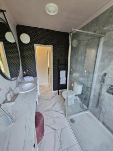 a bathroom with a sink and a shower and a toilet at Lazy Olives in Tongeren