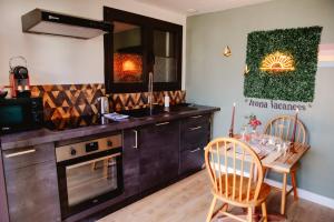 a kitchen with a table and chairs and a counter top at La Suite romantique des Chatons in Mimizan