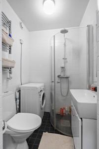 a bathroom with a toilet and a shower and a sink at Apartament u Ann in Grzędzice