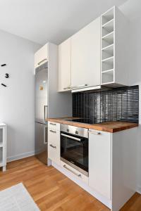 a kitchen with white cabinets and a stove at Apartament u Ann in Grzędzice +2 photos