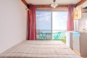 een keuken met een bed en uitzicht op de oceaan bij Jeux de boules 5 in Le Pradet