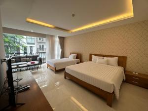 a hotel room with two beds and a couch at THE STAR HOTEL 2 - Phú Mỹ Hưng, Hồ Chí Minh in Ho Chi Minh City