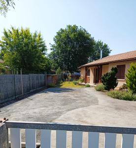 ein weißer Zaun vor einem Haus in der Unterkunft Maison de la famille et des amis in Biscarrosse