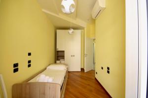 Una pequeña habitación con una cama y una pared amarilla. en HC - CloHouse Spacious Flat, en Roma