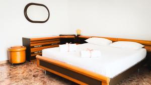 a bedroom with a bed with white sheets and a mirror at Canal Bellavista by Ca-Sa Check in Chioggia