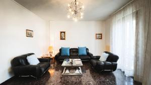 a living room with black leather furniture and a chandelier at Canal Bellavista by Ca-Sa Check in Chioggia