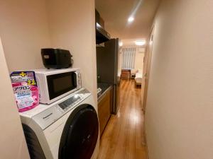 a kitchen with a microwave and a computer on top of it at Uhome Kamiitabashi Apartment in Tokyo