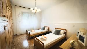 a bedroom with two beds and a chandelier at Canal Bellavista by Ca-Sa Check in Chioggia