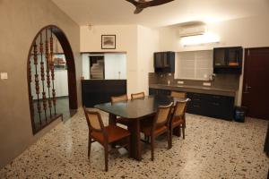 a kitchen with a dining room table and chairs at Coastline 4Bedroom cliffside villa in Elattūr +10 photos