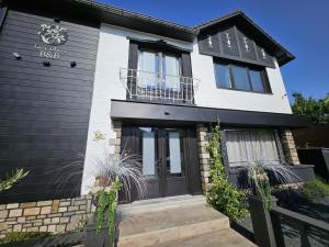 a black and white house with a black door at Lazy Olives in Tongeren
