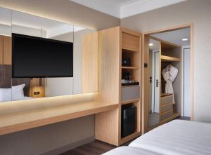 a bedroom with a flat screen tv and a bed at Crowne Plaza Rome St. Peter's by IHG in Rome