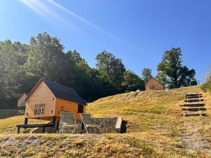 two chairs and a barn on a grassy hill at Podere Leucolea in Montagna