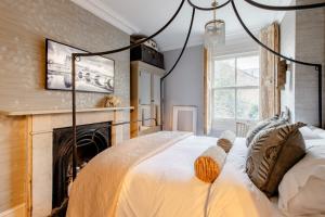 a bedroom with a large bed with a fireplace at Stylishly Designed Private Home in Central Windsor in Windsor