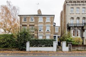an old brick building with bushes in front of it at Stylishly Designed Private Home in Central Windsor in Windsor