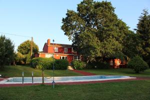 a red house with a pool in front of it at Casa de Piñeiro y SPA Opcional de in Santiago de Compostela