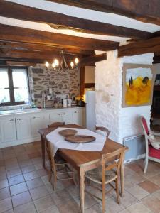 a kitchen with a wooden table and chairs in a kitchen at Gîte le pré des Colombes in Troche