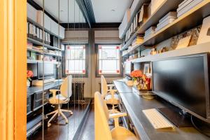 a library with a long table with a computer on it at Stylishly Designed Private Home in Central Windsor in Windsor