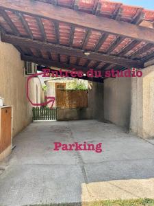a parking lot with a wooden pergola at Studio Bougainvillier in La Seyne-sur-Mer