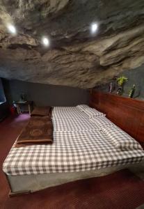 a bed in a room with a stone wall at Escape Natural Farm Stay - Cave 2 in Kanthalloor