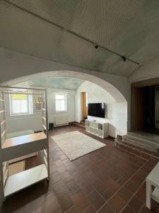 a living room with an archway and a television at Ferienwohnung am Nikolai-Felsen in Bautzen