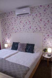 A bed or beds in a room at Amfora Panzió