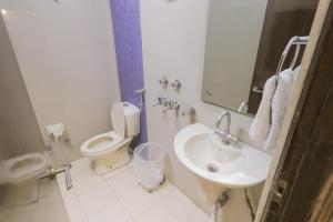 Un baño blanco con inodoro y lavabo. en Hotel Maharani Regency, en Zirakpur