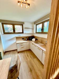 a kitchen with white cabinets and a table and windows at Zakątek Zakopane in Zakopane +39 photos