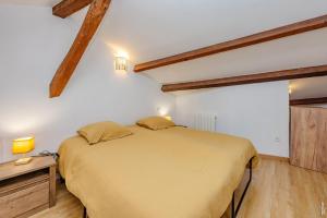 a bedroom with a large bed in a room with wooden ceilings at L'échappée Gaillacoise in Gaillac