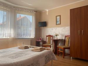 a bedroom with a bed and a table and chairs at Pokoje Gościnne DANA in Łeba