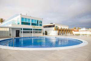 a large swimming pool in front of a building at Hotel Boutique TAO Caleta Mar in Corralejo