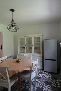 una cocina con una mesa y un refrigerador en Villa Gabriel, en Buis-les-Baronnies