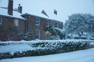 una casa cubierta de nieve en un patio en Heronshaw House en Hurn