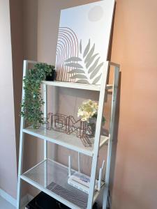 a white shelf with plants on it next to a wall at Taiping Centre Point Suite 7 by BWC in Taiping