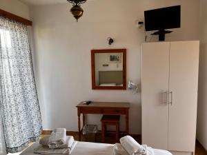 a bedroom with a bed and a mirror and a desk at Pericles Studios in Agia Marina Aegina
