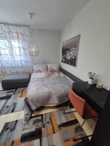 a bedroom with a bed and a desk in it at D&D Studio Apartment in Velika Gorica