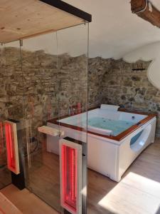 a hot tub in a room with a stone wall at "Rosa di sera" - Relax in Toscana con Spa privata in Tresana +37 photos