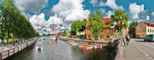 a river with boats in it in a city at Manto Apartment in Klaipėda