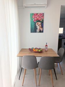 een eettafel met 2 stoelen en een fruitschaal bij Platanou 21 Apartments in Kremasti
