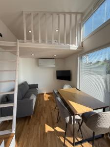 a living room with a loft bed and a table and chairs at Tiny-Village by CasaVia in Eisingen