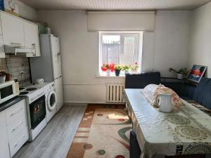 a small kitchen with a table and a microwave at Guest house Anel in Tebykty