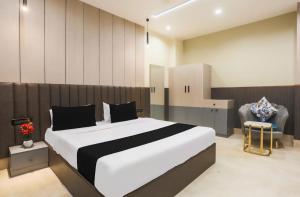 a bedroom with a large bed and a chair at Hotel heritage plaza in Hisār