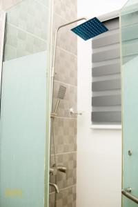 Una ducha con puerta de cristal y techo azul. en iSoZo Luxury Stays Apartment 2, en Ikeja