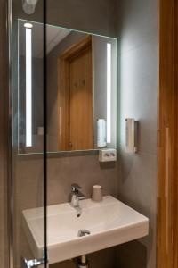 a bathroom with a sink and a mirror at Havila Hotel Geiranger in Geiranger