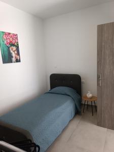 een slaapkamer met een blauw bed en een tafel bij Platanou 21 Apartments in Kremasti