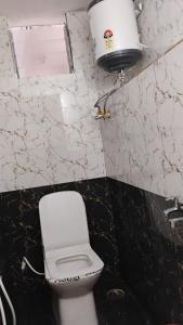 a bathroom with a white toilet and a sink at Misty Meadows Ooty in Ooty