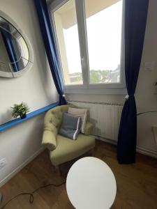 un salon avec une chaise et une table dans l'établissement Chambres avec espaces communs équipés parfait pour séjour professionnel ou ambiance conviviale, à Laval