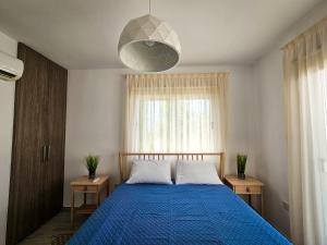 a bedroom with a blue bed and a large window at Nissi beach villa Azure in Ayia Napa +37 photos