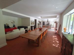 Una sala de estar con una mesa de madera y un sofá. en Le grand mas du Couchadou, en Pernes-les-Fontaines