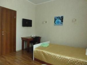 車里雅賓斯克的住宿－Mini-Hotel Nikolskaya，客房设有一张床、一张桌子和一张书桌。