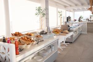 a buffet line with bread and other food items at Hotel Boutique TAO Caleta Mar in Corralejo +37 photos